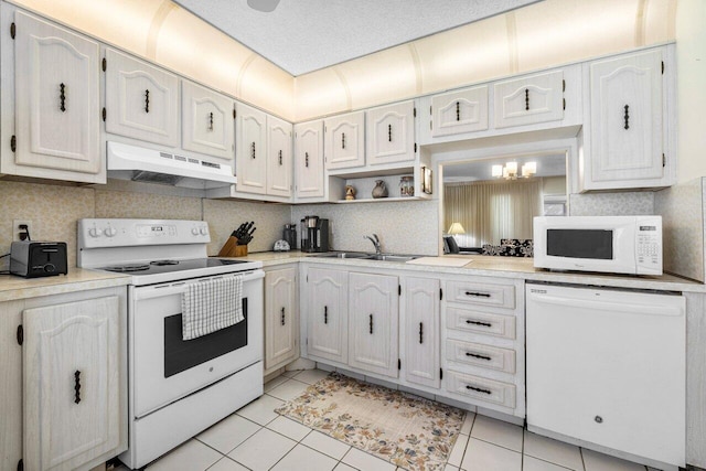 kitchen featuring tasteful backsplash, white cabinetry, sink, light tile patterned floors, and white appliances