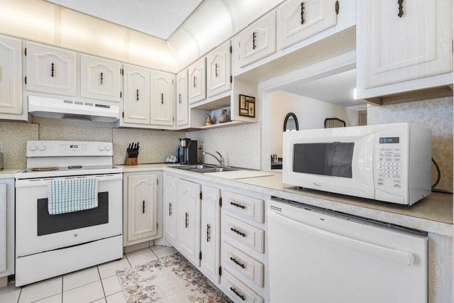 kitchen with sink, white appliances, white cabinetry, backsplash, and light tile patterned flooring