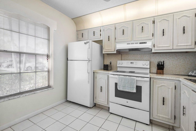 kitchen with tasteful backsplash, light tile patterned floors, white appliances, and white cabinets