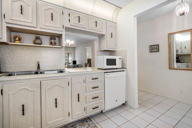 kitchen featuring tasteful backsplash, white appliances, light tile patterned flooring, and sink