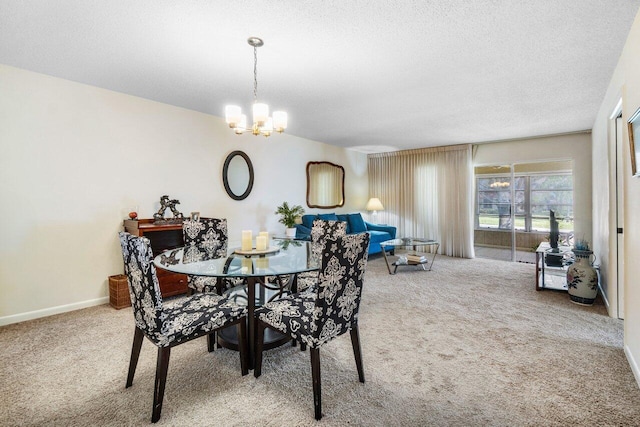 dining room featuring a chandelier, carpet floors, and a textured ceiling