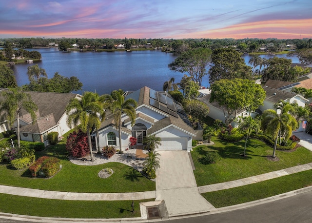 aerial view at dusk featuring a water view