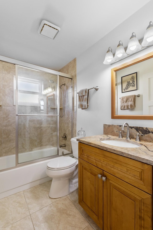 full bathroom featuring enclosed tub / shower combo, vanity, tile patterned floors, and toilet