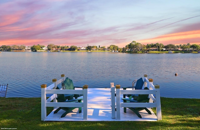 dock area with a water view and a lawn