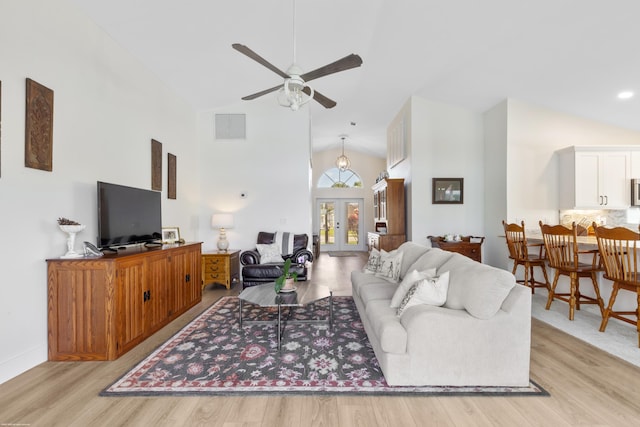 living room with light hardwood / wood-style flooring, high vaulted ceiling, french doors, and ceiling fan