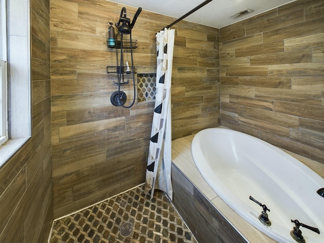 bathroom with wooden walls and shower with separate bathtub