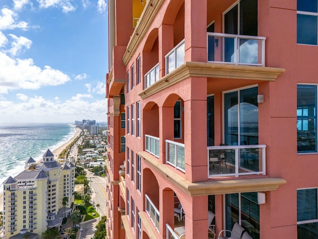 view of building exterior featuring a water view and a view of the beach