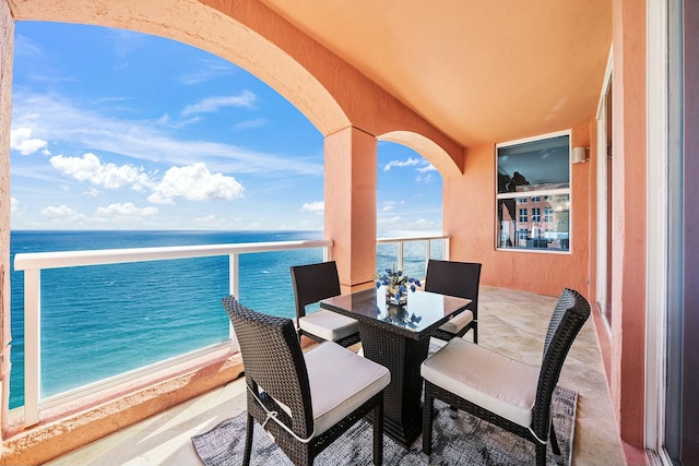 balcony with a water view and a view of the beach