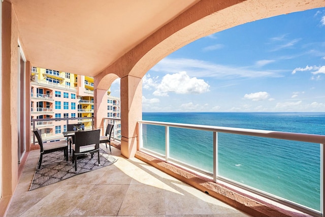 balcony featuring a water view and a beach view