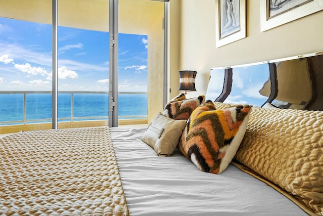 bedroom featuring a water view and access to exterior