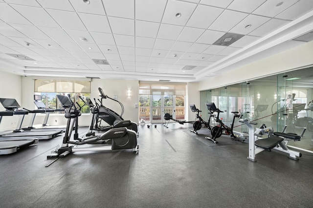 exercise room with a drop ceiling and a healthy amount of sunlight