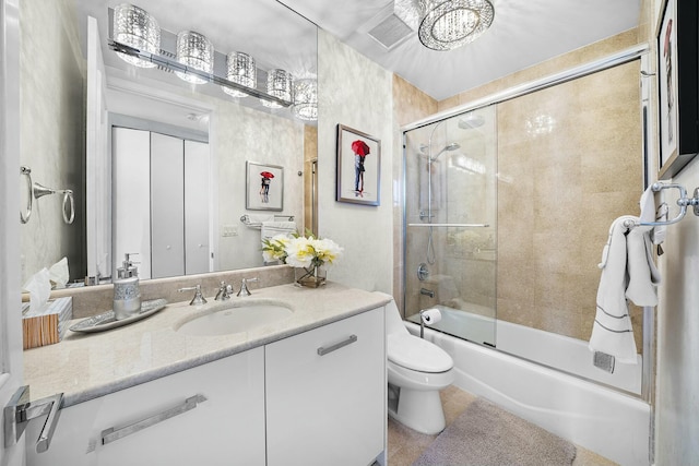 full bathroom featuring toilet, vanity, and shower / bath combination with glass door