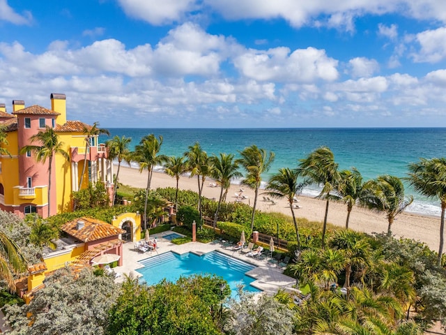 view of pool featuring a view of the beach, a patio area, and a water view