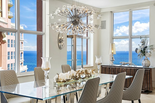 dining space featuring a water view, a wealth of natural light, and a chandelier