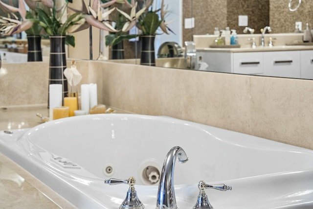 bathroom featuring sink and tiled bath