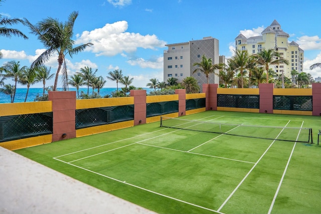 view of tennis court with a water view