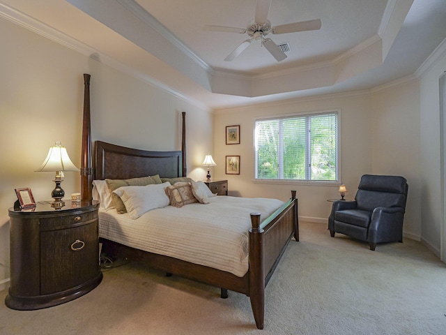 bedroom featuring crown molding, light colored carpet, a tray ceiling, and ceiling fan