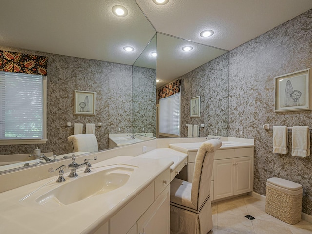 bathroom with vanity, tile patterned flooring, a textured ceiling, and a bathtub