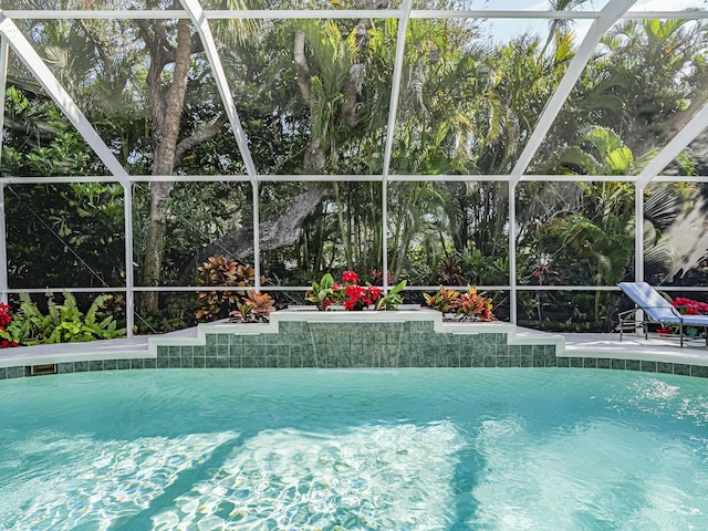 view of swimming pool featuring a lanai