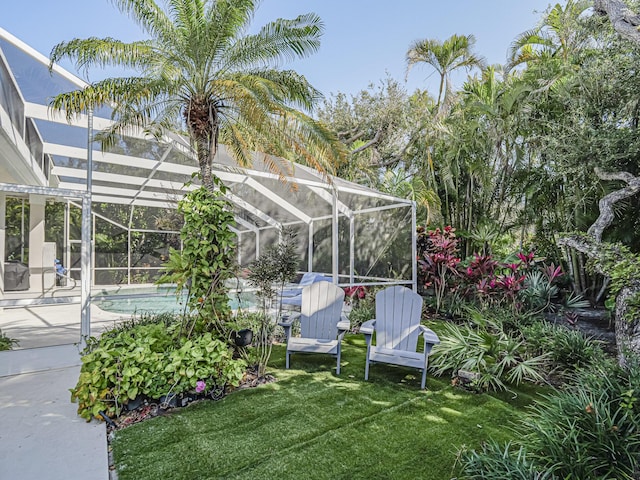 view of yard with glass enclosure and a patio area