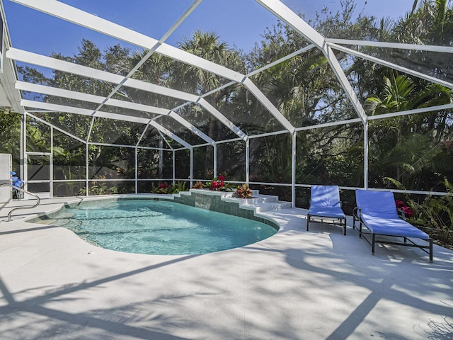 view of swimming pool featuring a patio and glass enclosure