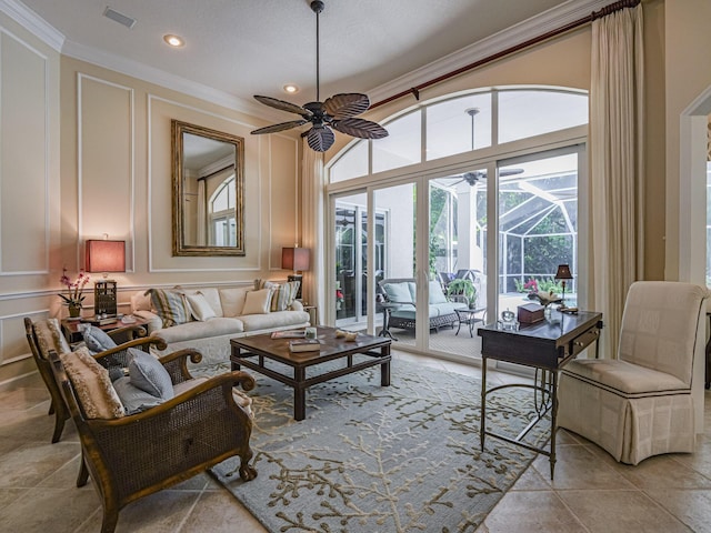 living room featuring light tile patterned floors, crown molding, ceiling fan, and a towering ceiling