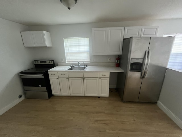 kitchen featuring light wood-type flooring, stainless steel appliances, sink, and white cabinets