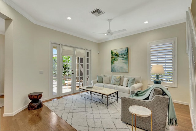 living room featuring ornamental molding, ceiling fan, and light hardwood / wood-style floors