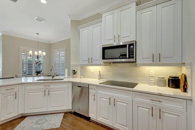 106 Via Santa Cruz, Jupiter, FL 33458 - kitchen with stainless steel appliances, a sink, crown molding, light wood finished floors, and tasteful backsplash