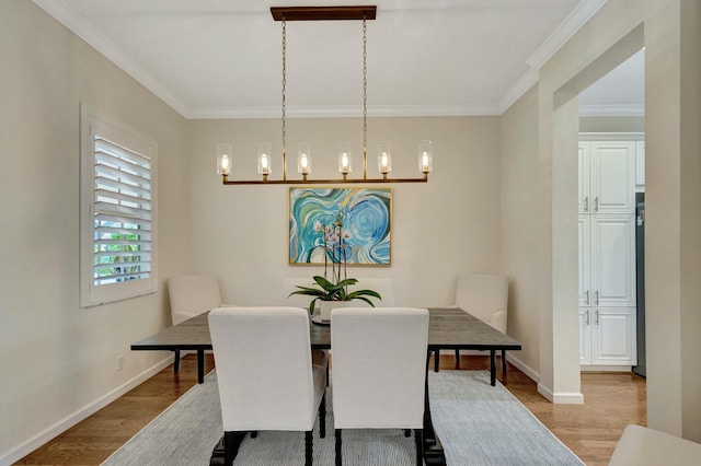 dining area featuring ornamental molding and light hardwood / wood-style floors