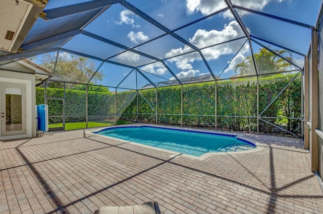 view of swimming pool with a patio area and glass enclosure