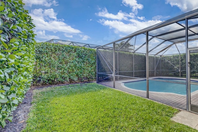 view of swimming pool featuring a yard and glass enclosure