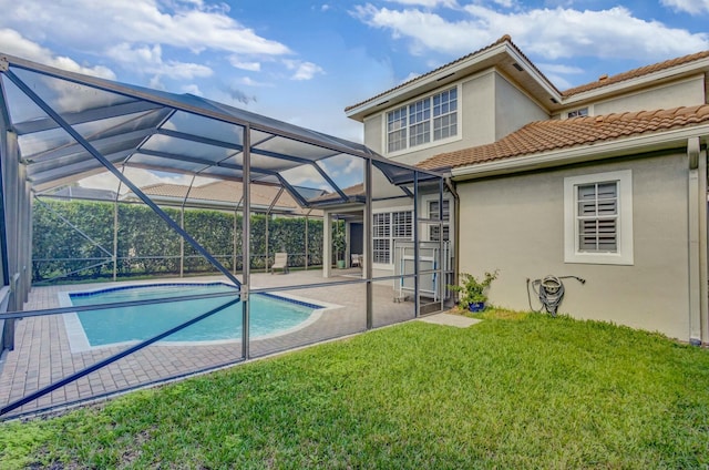 view of swimming pool with a patio, glass enclosure, and a lawn