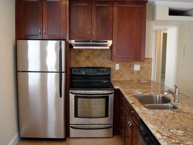 kitchen featuring tasteful backsplash, sink, stainless steel appliances, and light stone countertops