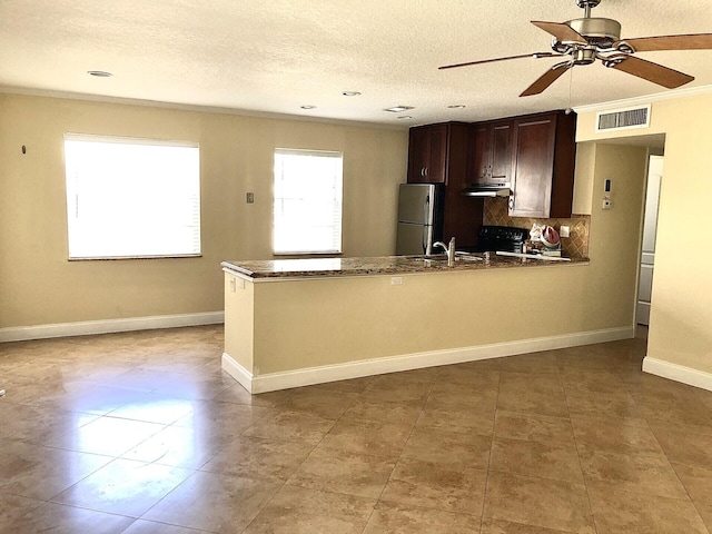 kitchen with black electric range, dark brown cabinets, a textured ceiling, stainless steel refrigerator, and ornamental molding