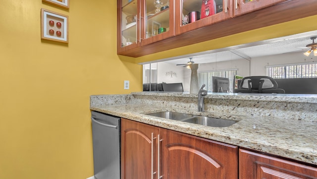 kitchen with dishwasher, light stone countertops, sink, and ceiling fan