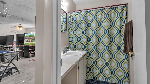 bathroom with vanity, ceiling fan, and a textured ceiling