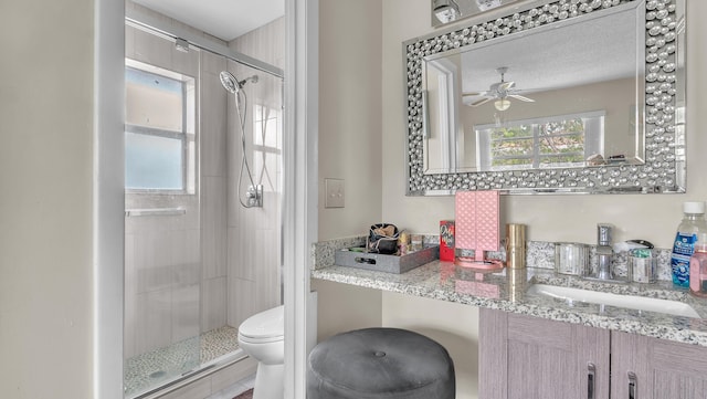 bathroom with vanity, an enclosed shower, ceiling fan, and toilet