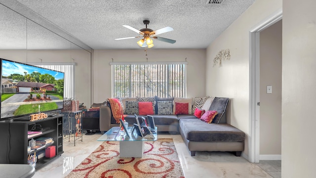 living room with a textured ceiling and ceiling fan