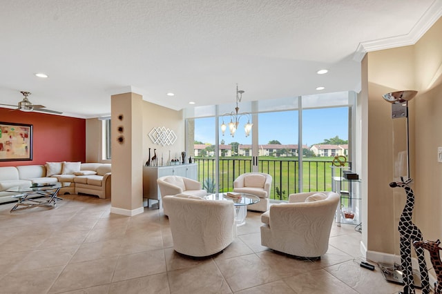 tiled living room with ceiling fan with notable chandelier, ornamental molding, floor to ceiling windows, and a textured ceiling