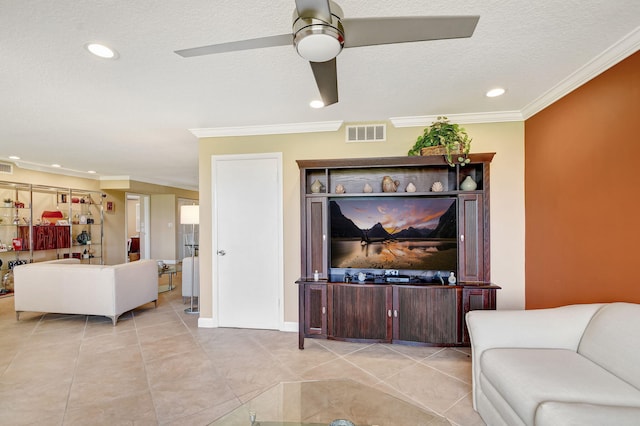 living room with ceiling fan, ornamental molding, a textured ceiling, and light tile patterned floors