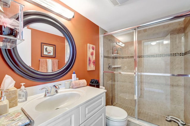 bathroom featuring vanity, toilet, and an enclosed shower