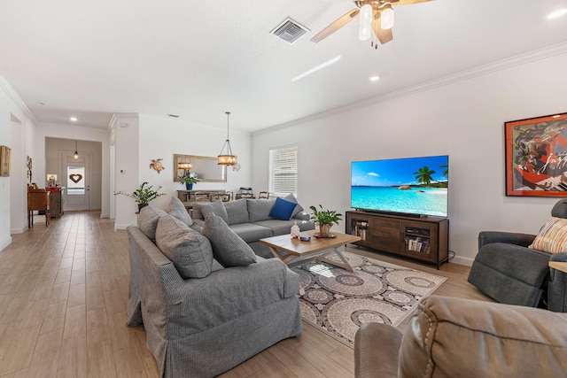 living room with ornamental molding and light hardwood / wood-style floors