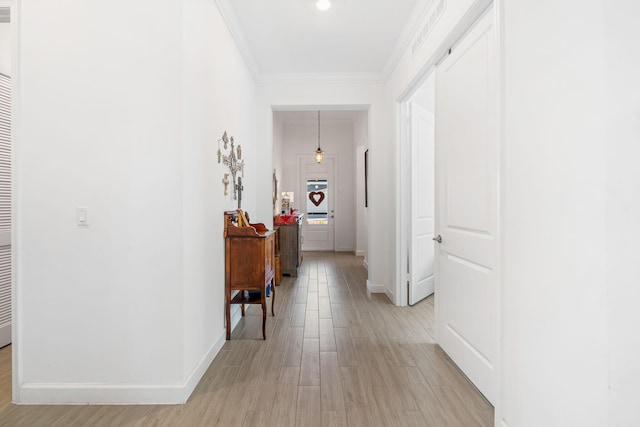 hallway featuring ornamental molding and light wood-type flooring