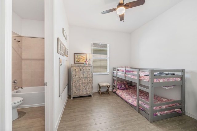 bedroom with ensuite bathroom, ceiling fan, and light wood-type flooring