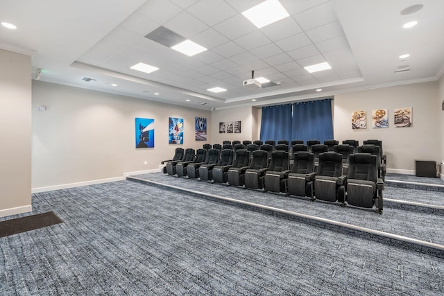 home theater room with carpet floors, ornamental molding, and a raised ceiling