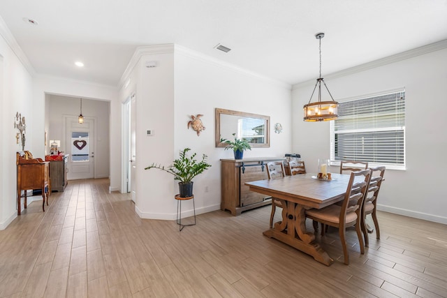 dining room featuring an inviting chandelier, light hardwood / wood-style flooring, and ornamental molding