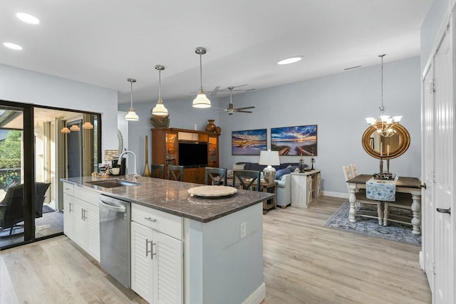 kitchen featuring sink, white cabinetry, stainless steel dishwasher, pendant lighting, and dark stone counters