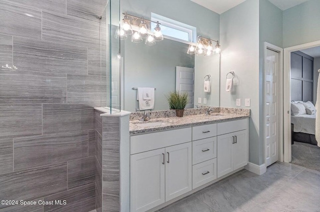 bathroom featuring tiled shower and vanity