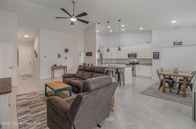 living room with a high ceiling, sink, and ceiling fan